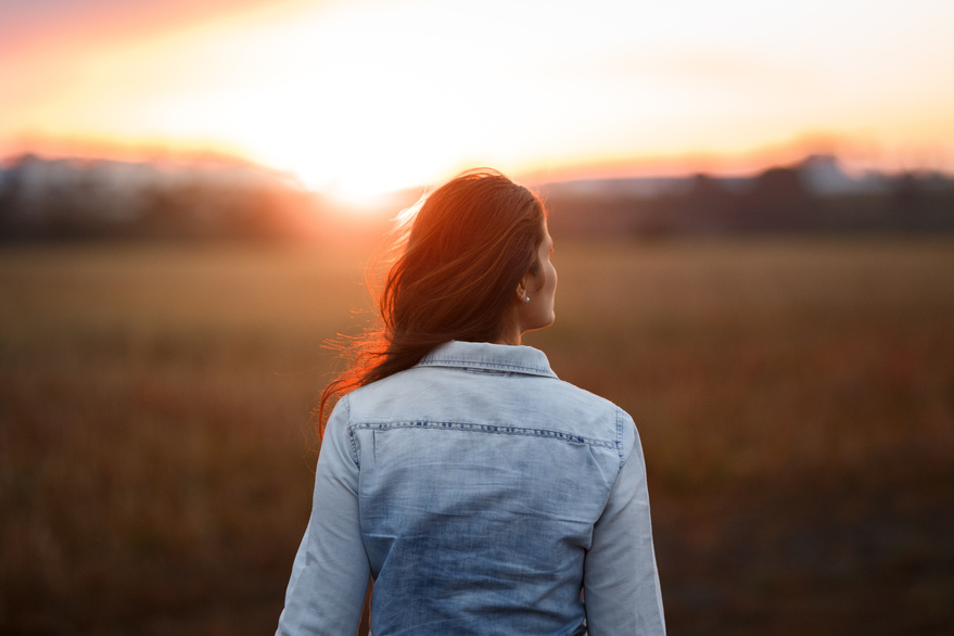 Woman walking towards sunset